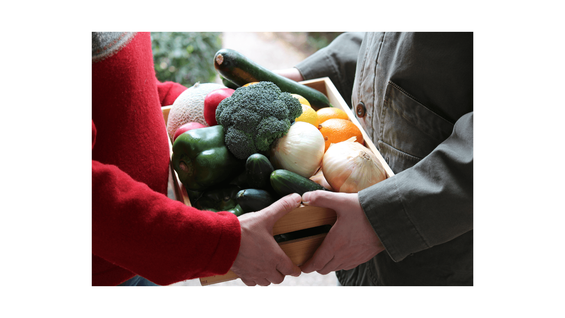 Handing off a box of fresh vegetables